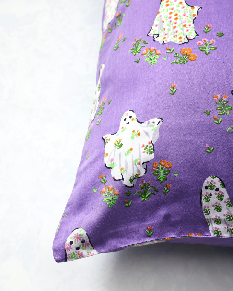 Purple Gardening Ghosts pillowcase shown close up, with white floral ghosts and scattered flowers.