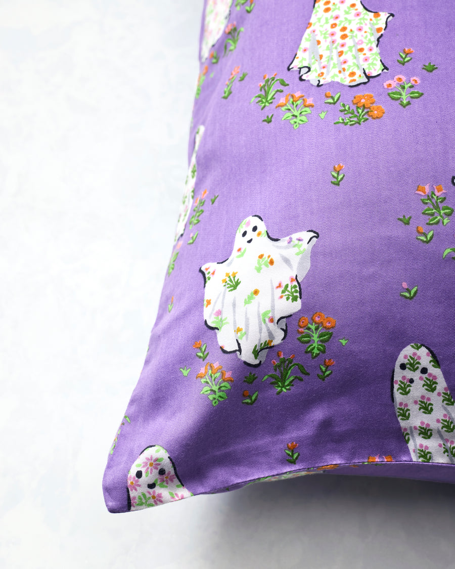 Purple Gardening Ghosts pillowcase shown close up, with white floral ghosts and scattered flowers.
