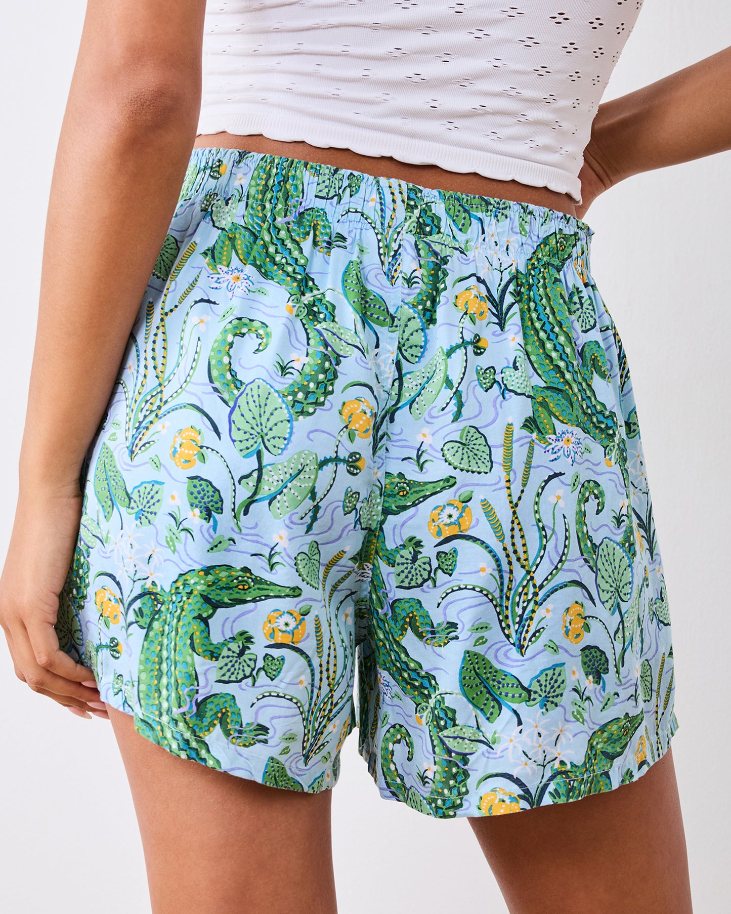 Close-up of boyfriend boxer shorts with an alligator, foliage, and floral print