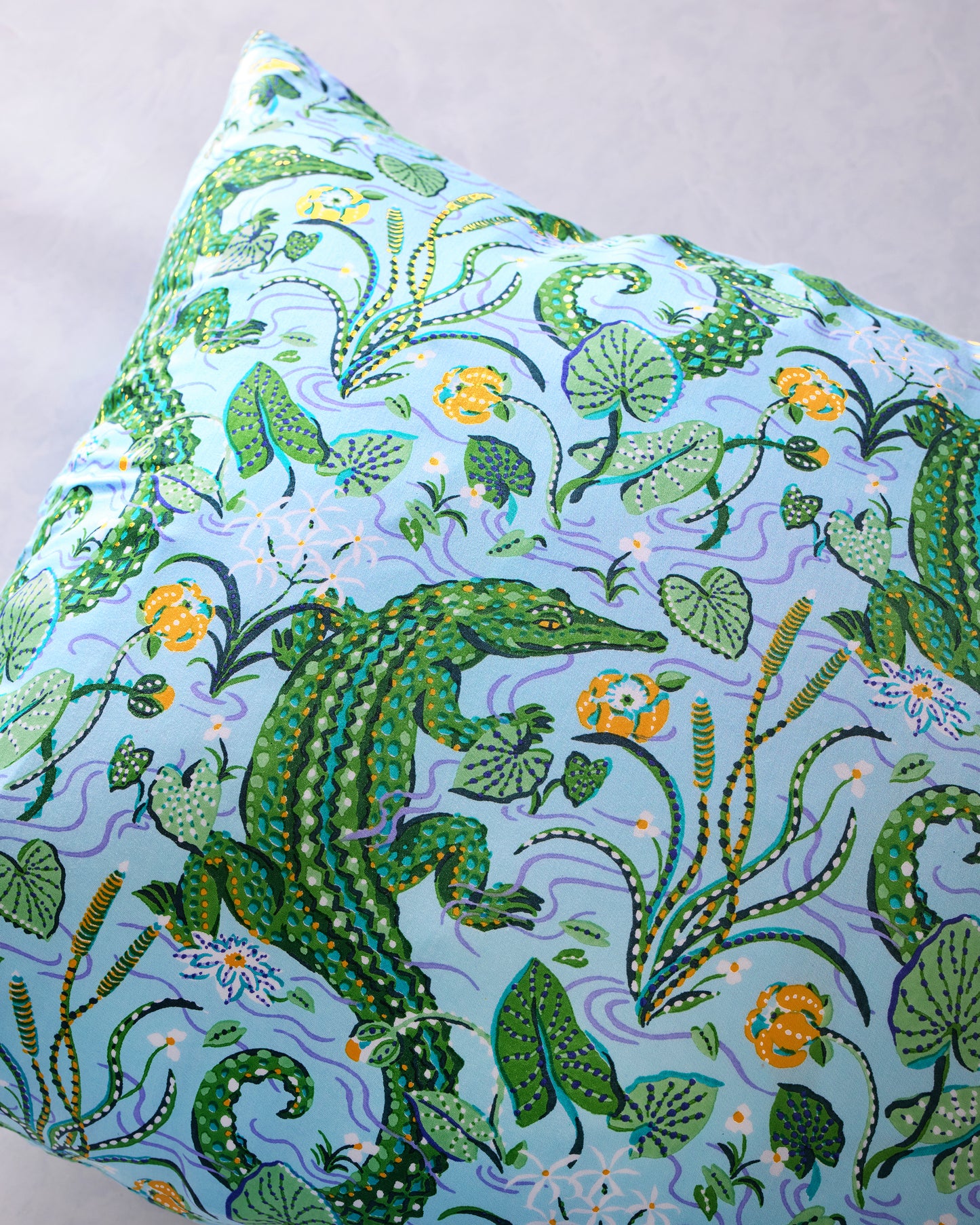Close-up of the pillowcase's alligator, foliage, and floral print