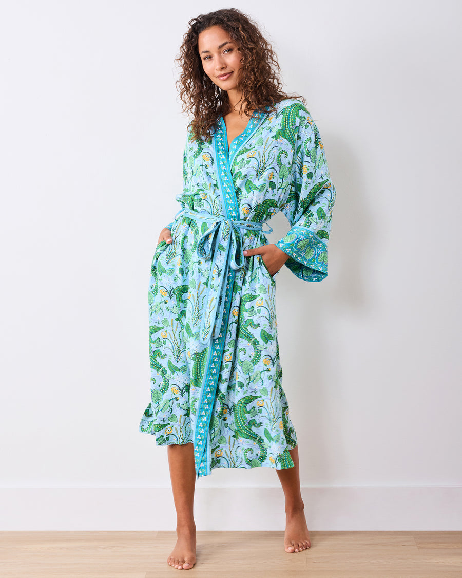 Front full-length view of the alligator-print robe worn belted with hands in the pockets