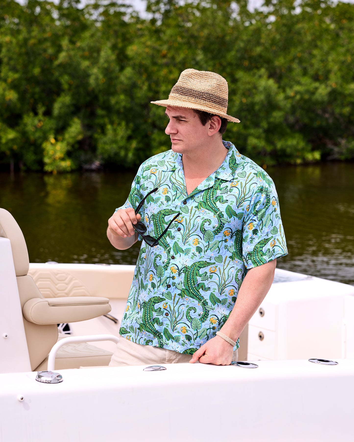 Front view of the Blue Lagoon alligator-print camp shirt worn on a boat