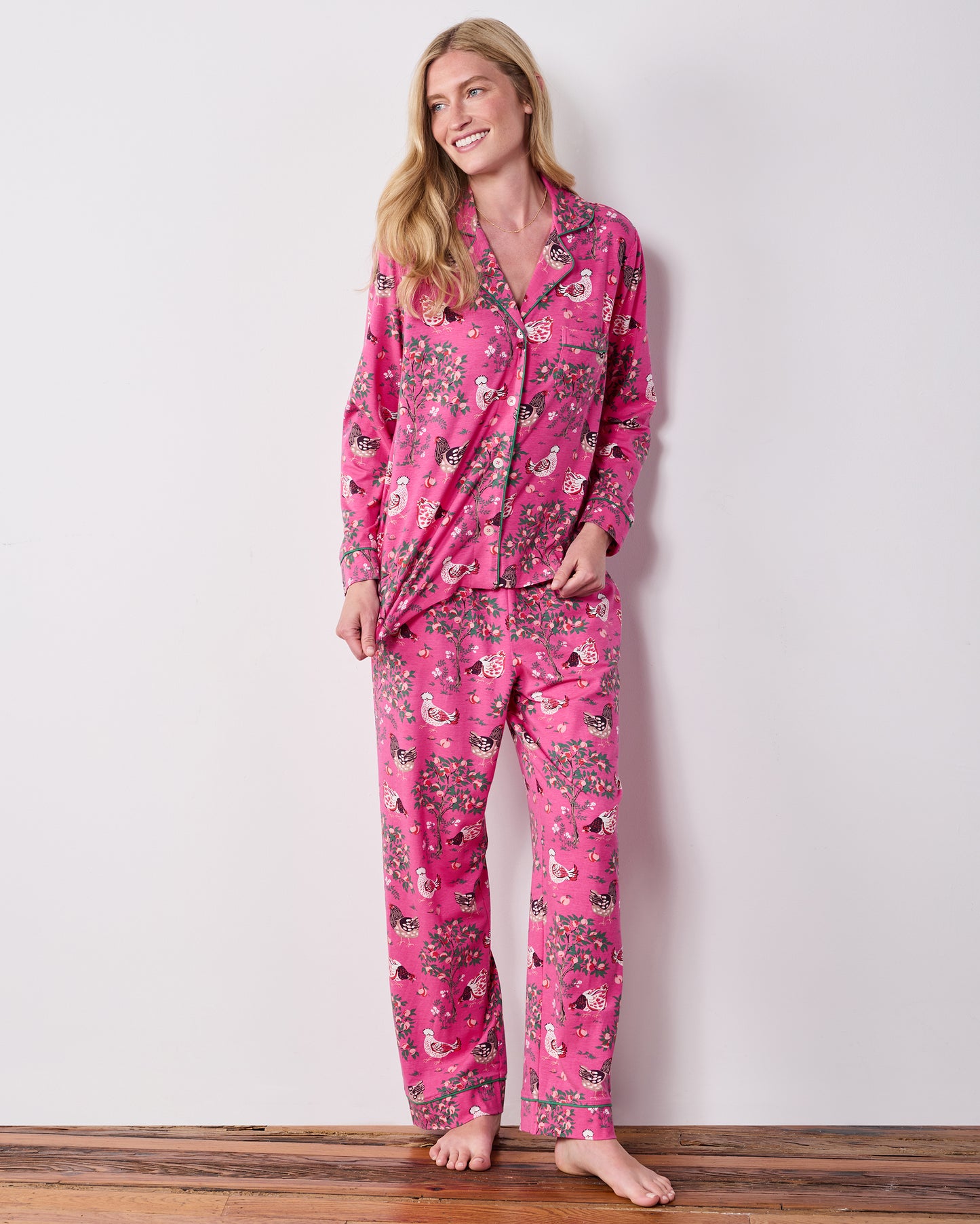 Full-length view of the Rose Pop Hen House long pajama set with a collared button-down top and matching full-length pants printed with chickens and flowering branches.