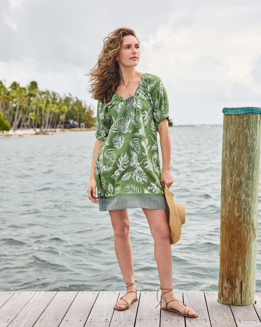 Full front view of the olive grove Annie Dress with gathered tie neckline, leaf-and-heron print, and striped hem