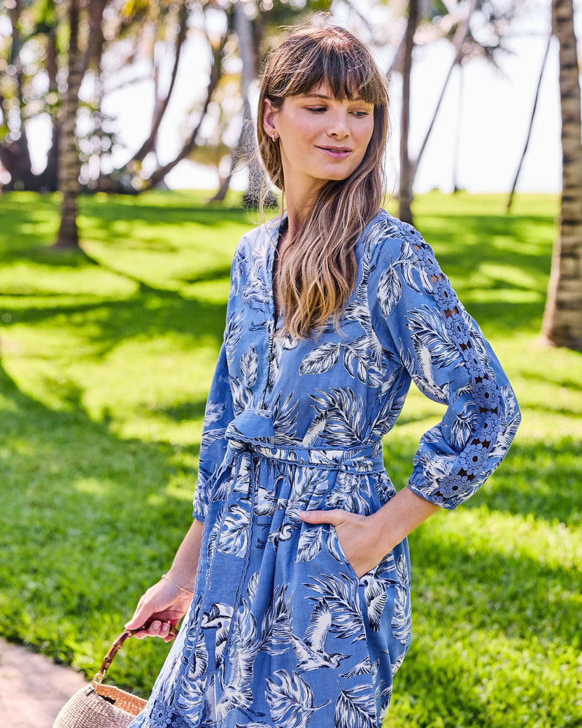 Three-quarter view of the Monroe dress showing its buttoned bodice, tie belt, pocket, and sleeve lace