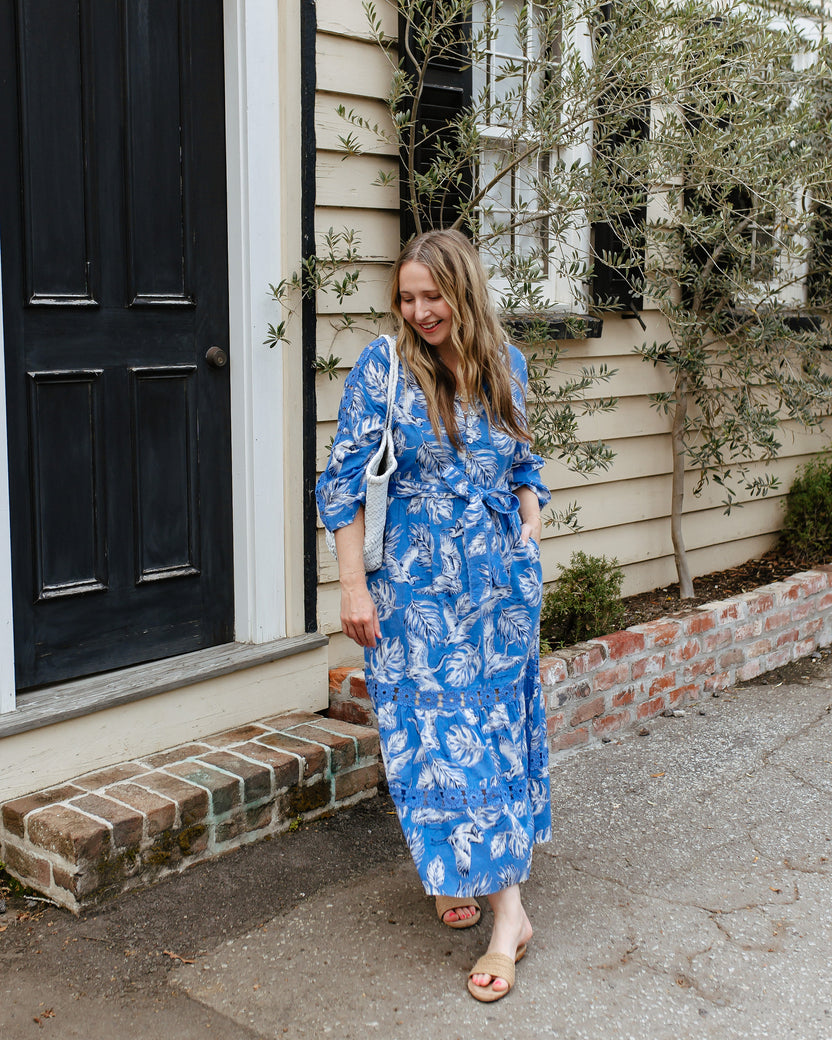 Person wearing the blue Heron Landing Monroe midi dress with a belt and pockets outdoors.