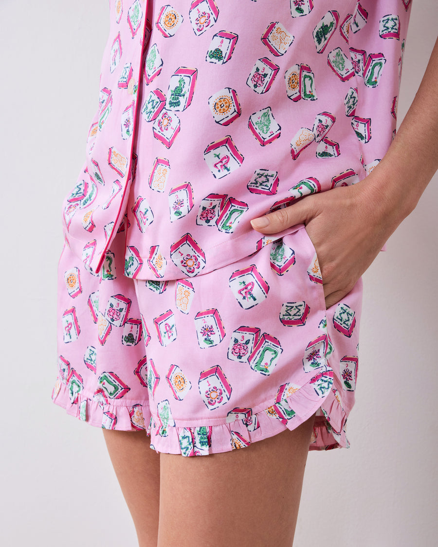 Close-up of the Lucky Tiles print, shorts pocket, curved hem, and ruffle trim.