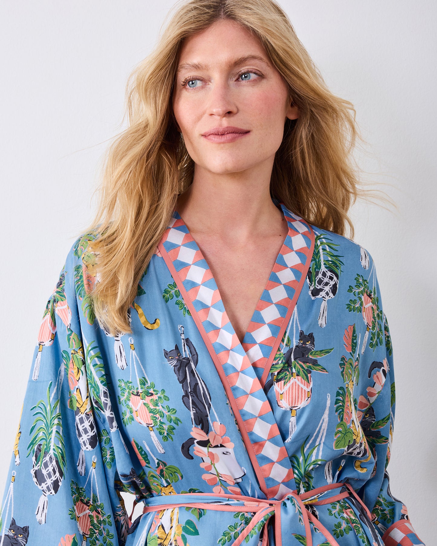 Upper front view of the slate blue robe with geometric lapels and cat-and-houseplant print