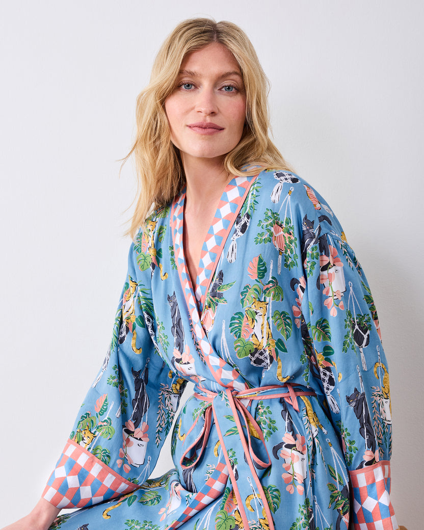 Seated three-quarter view of the slate blue robe with tied belt and wide patterned cuffs