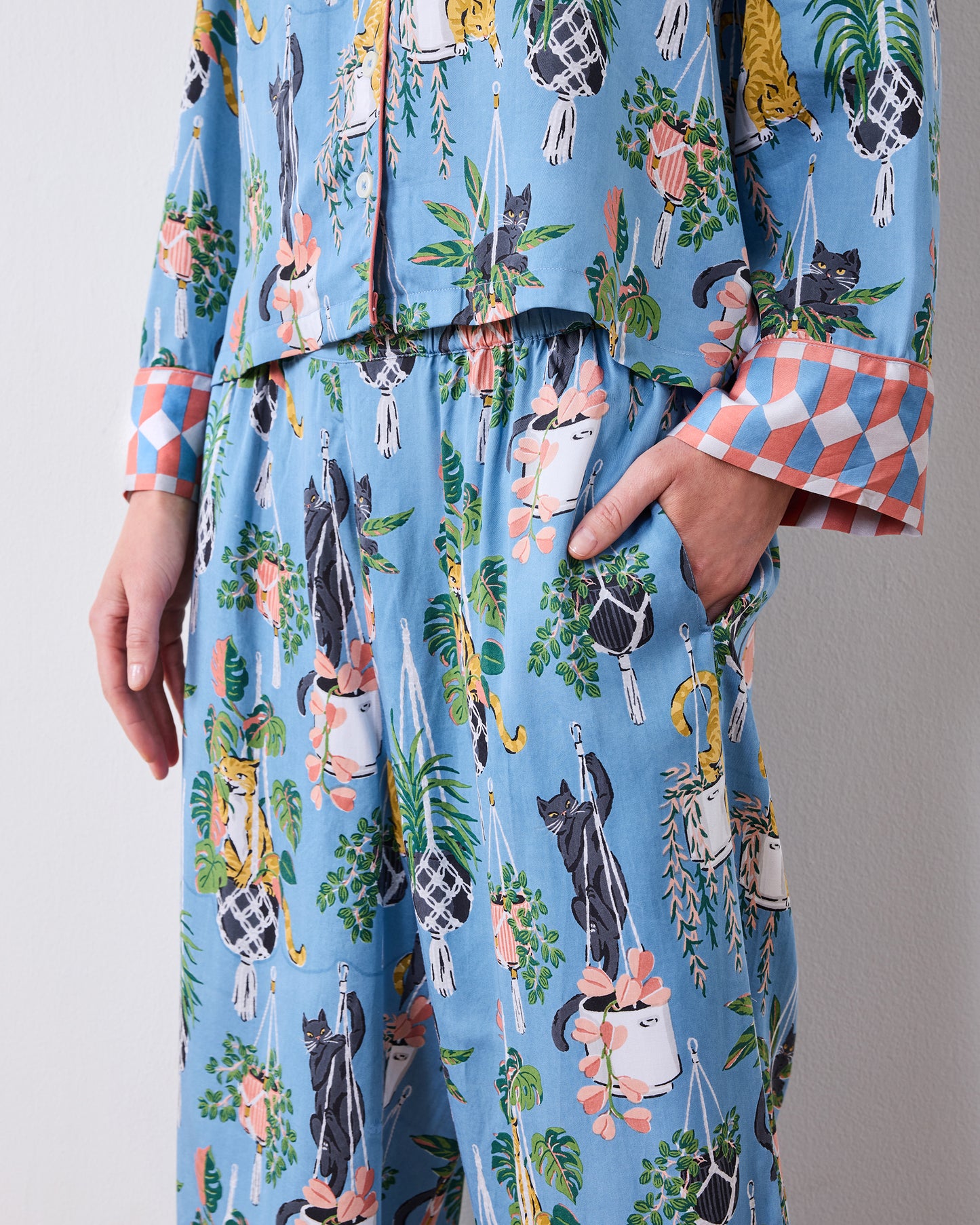 Close-up of the pajama set's wide-leg pants, side pocket, and cat-and-houseplant print