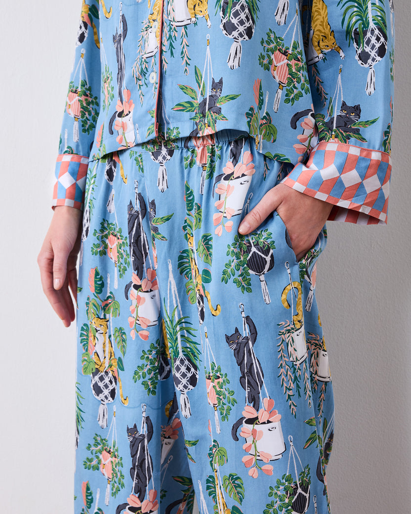 Close-up of the pajama set's wide-leg pants, side pocket, and cat-and-houseplant print