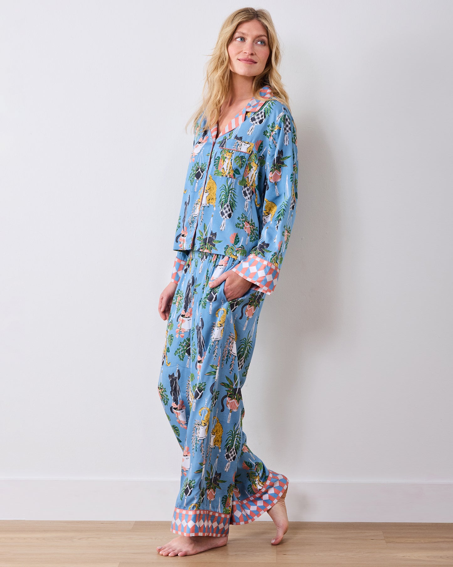 Full-length front view of the slate-blue pajama set with wide-leg pants and a cat-and-houseplant print