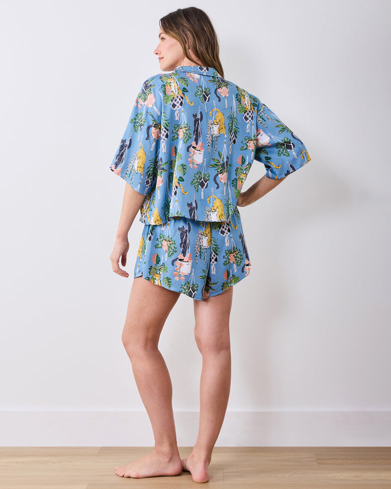 Full back view of the slate blue short pajama set with cats and hanging plants print