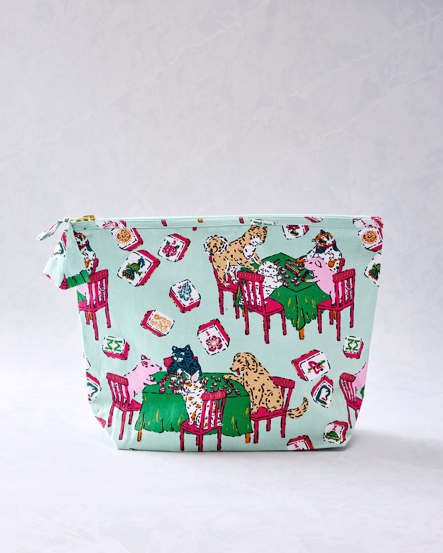 Pale jade essentials pouch with a zipper and a Mah Jongg-themed print featuring animals, game tables, chairs, and tiles.