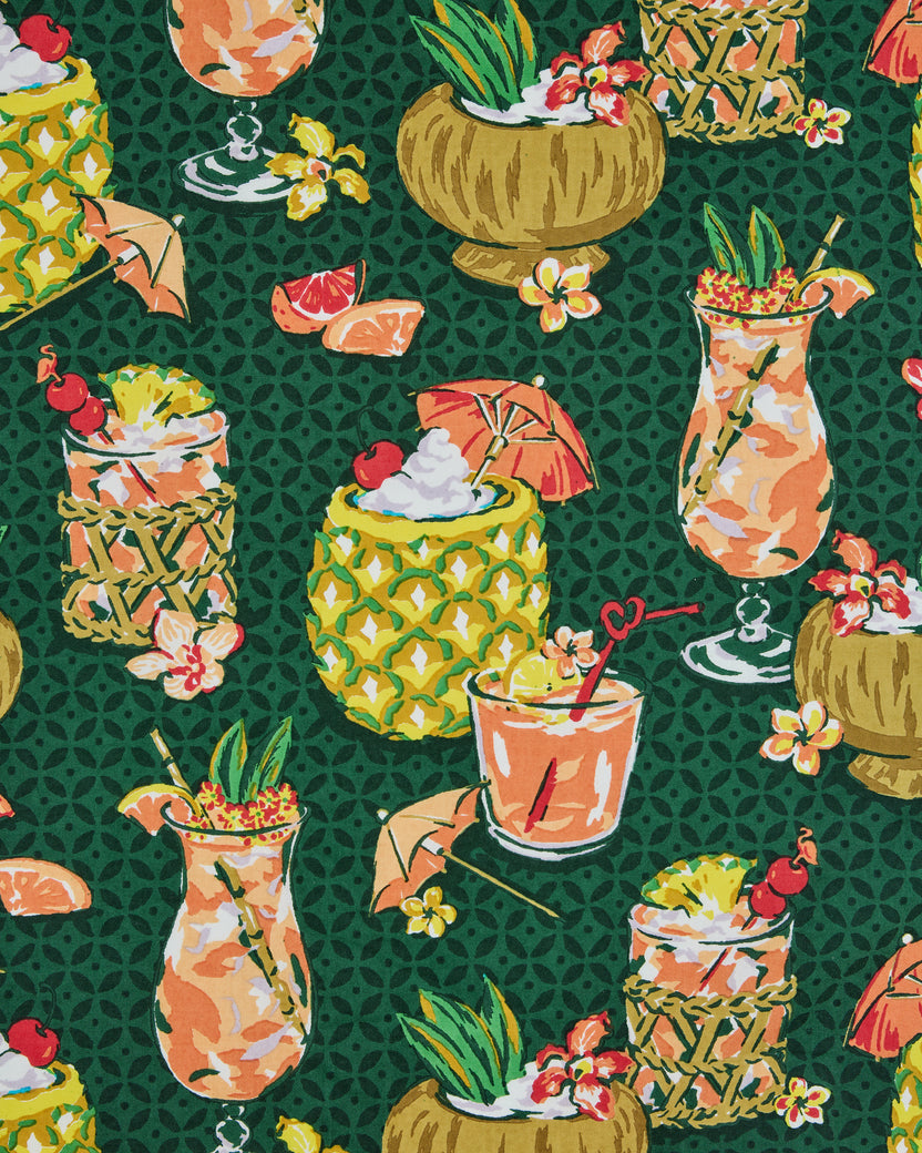 Close view of the green print featuring tropical drinks in pineapples, coconuts, and glasses with fruit and flowers
