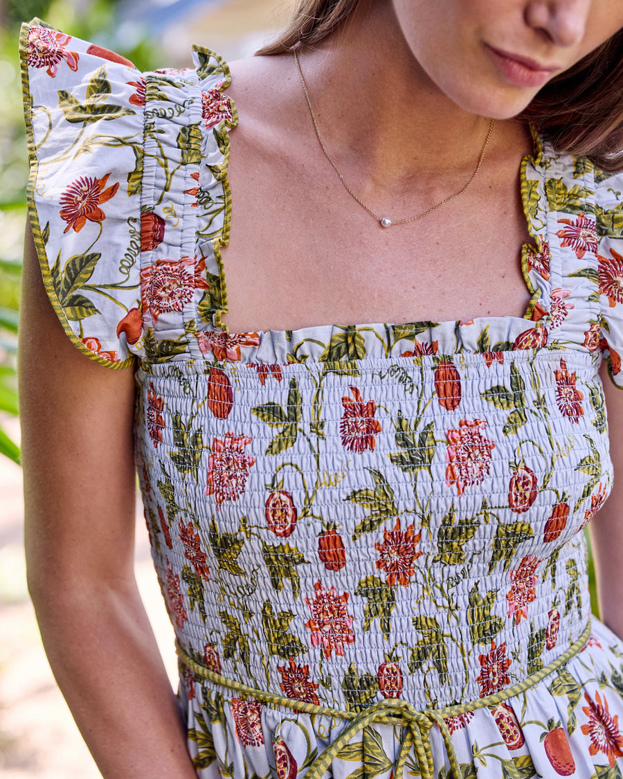 Close-up of the Billie Dress showing the smocked bodice, square neckline, ruffled straps, and tied belt
