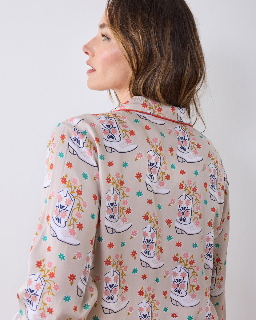 Back view of the long-sleeve pajama top showing its floral cowboy-boot print and red-trimmed collar.