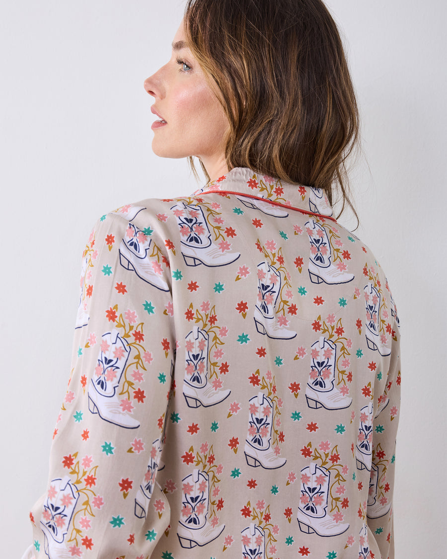 Back view of the long-sleeve pajama top showing its floral cowboy-boot print and red-trimmed collar.