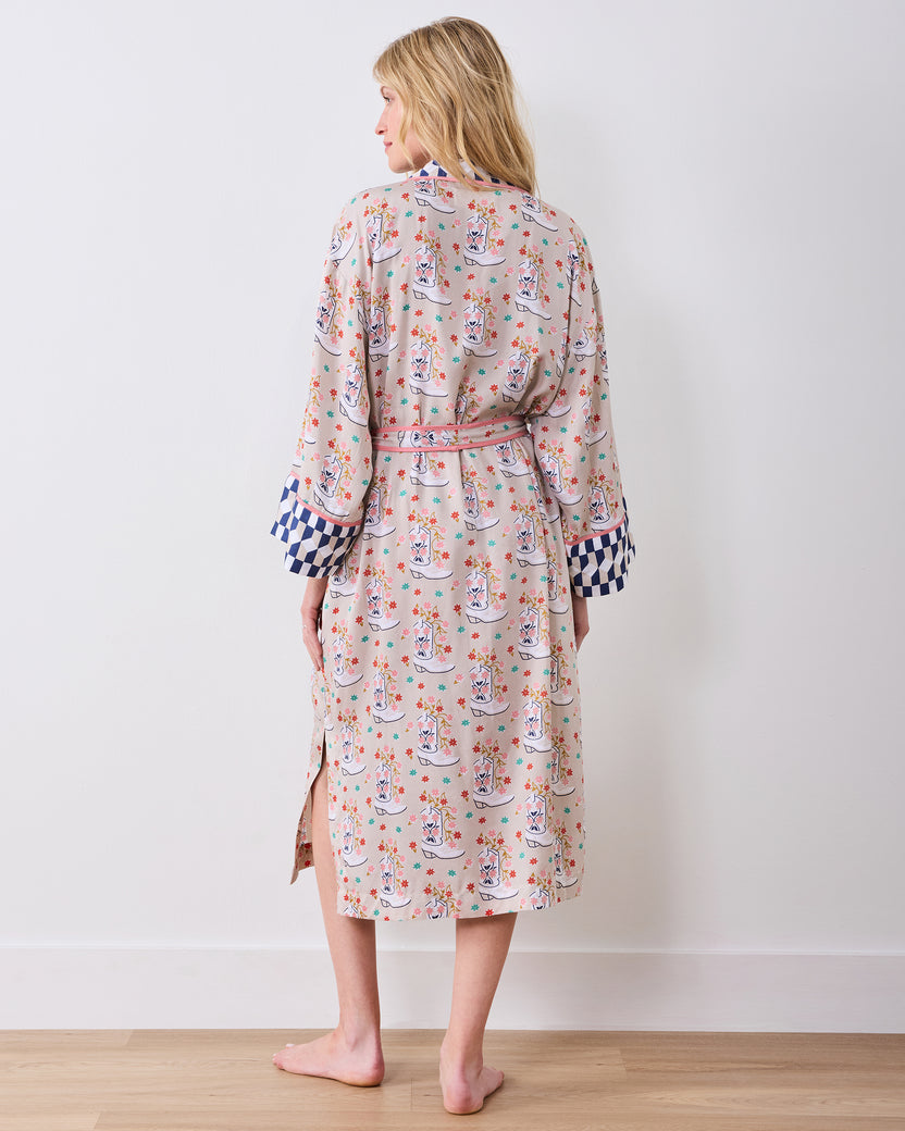 Back view of a model wearing a printed knee-length robe with a tied belt and side slits.