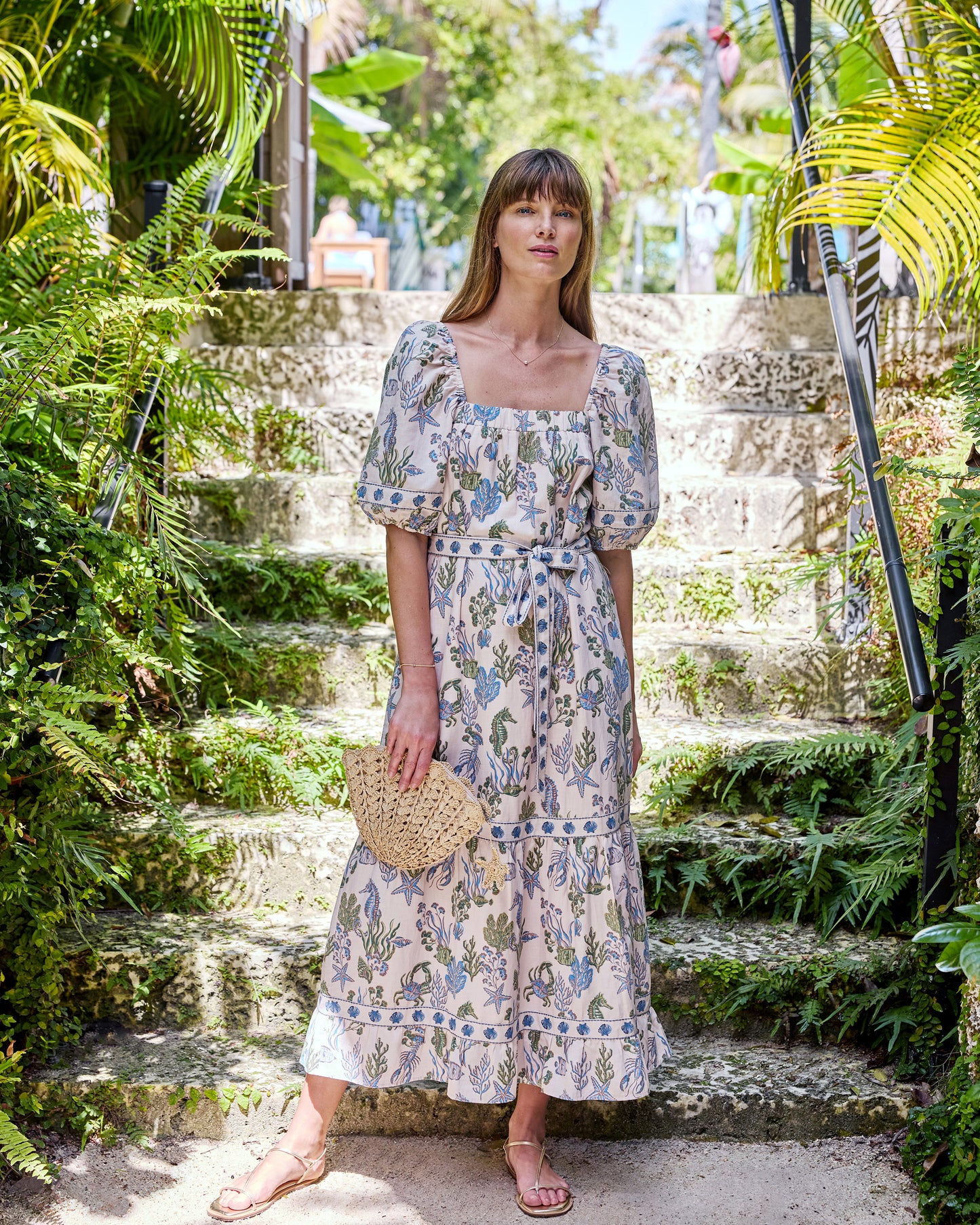 Full-length front view of the sand Collins Dress with square neckline, puff sleeves, sea-life print, tied belt, and tiered hem