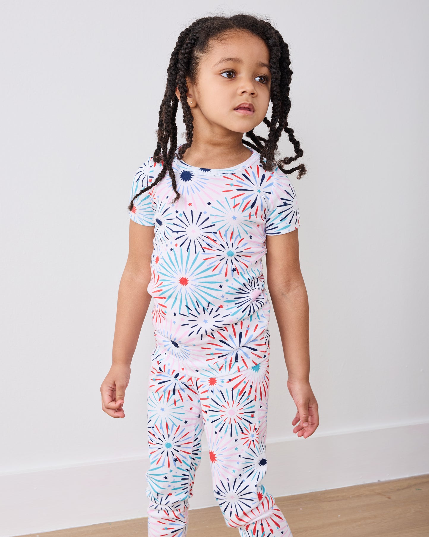 Standing front view of the fireworks-print short-sleeve pajama top and matching pants
