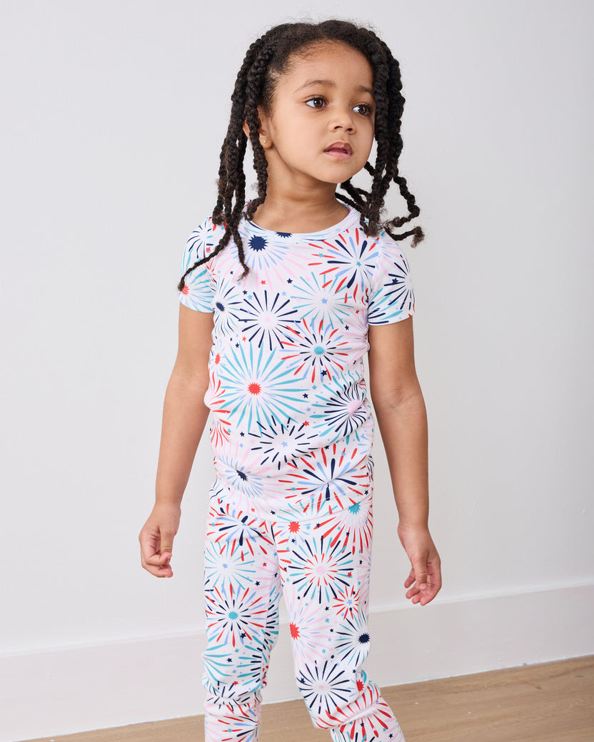 Standing front view of the fireworks-print short-sleeve pajama top and matching pants