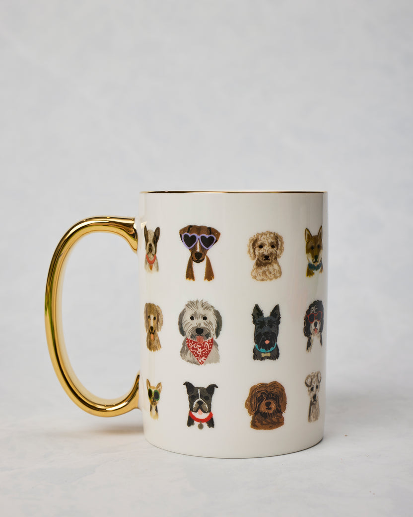 Dog Days porcelain mug shown from the side with a gold handle, gold rim, and rows of illustrated dogs wearing accessories.