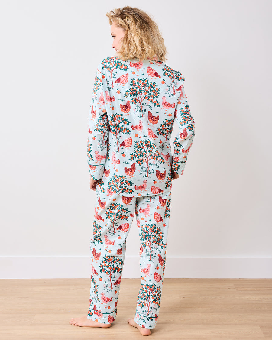 Back view of the long pajama set with a chicken and fruit-tree print on a light blue background