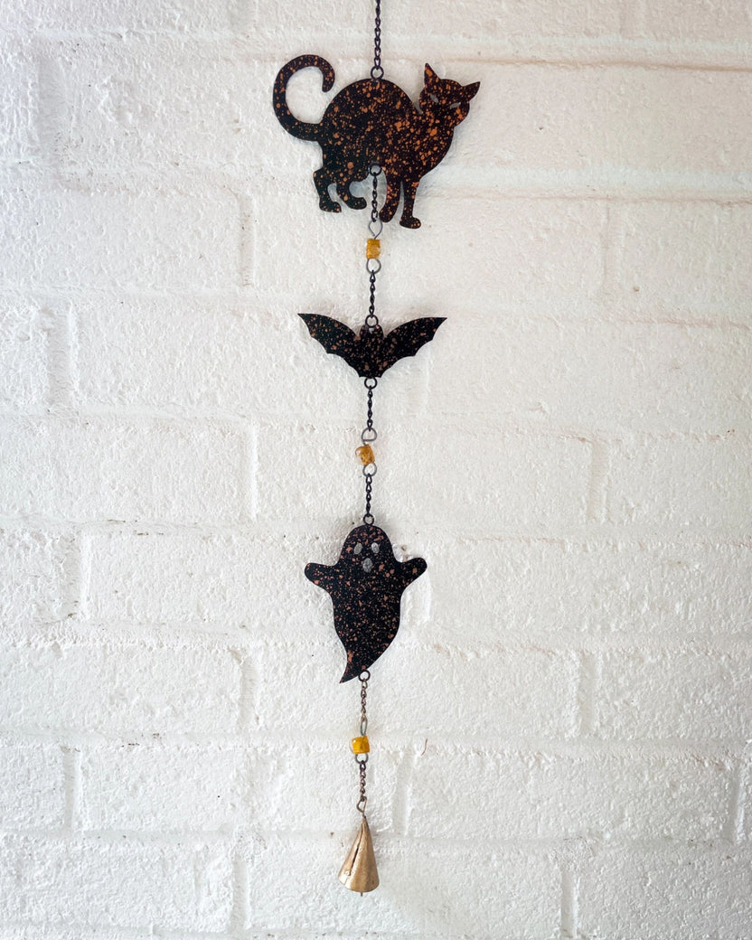 Black Halloween wind chime with cat, bat, and ghost cutouts linked by chains and ending in a bell.