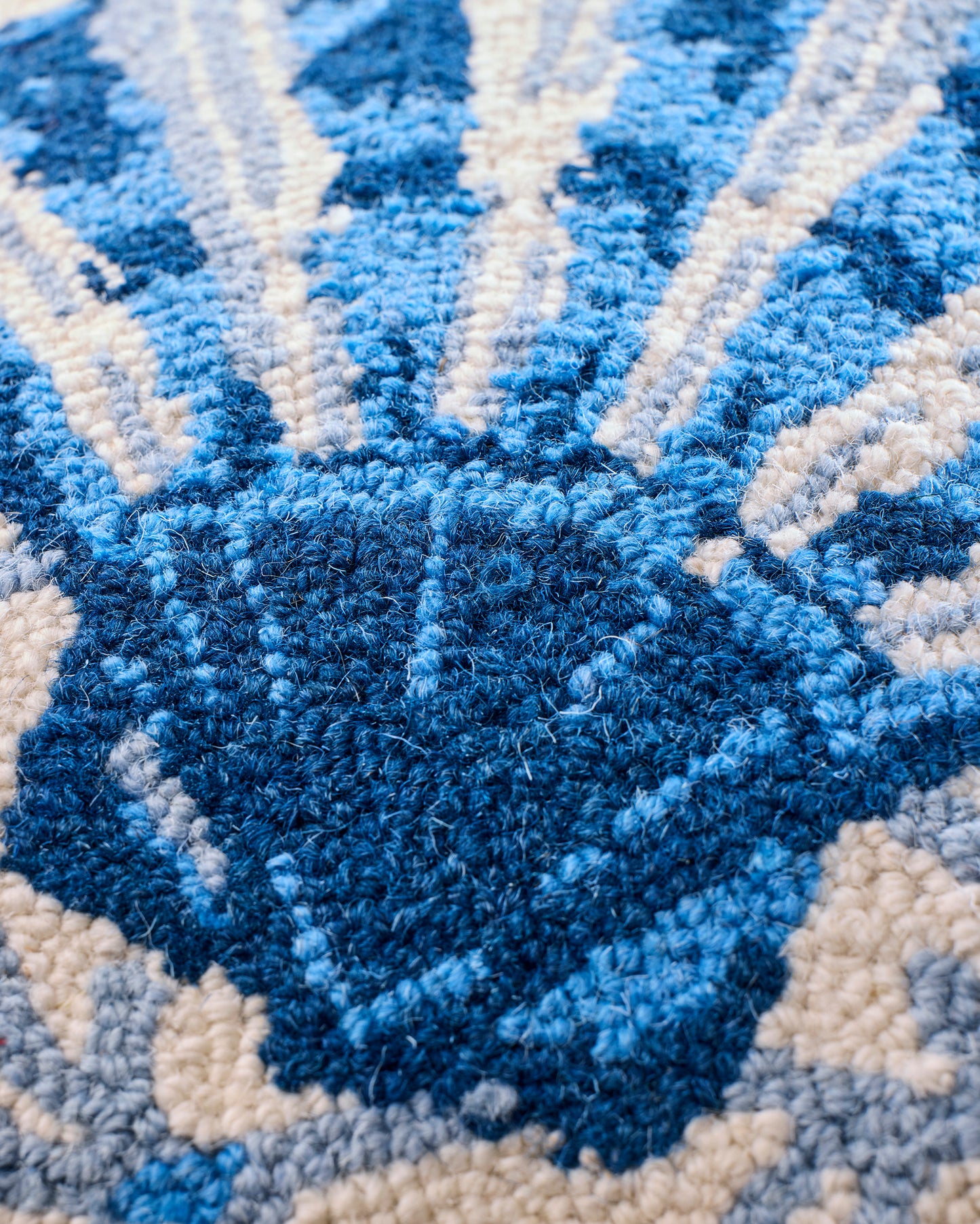 Close-up of the blue scallop shell pillow’s hooked stitching and layered blue-and-white design.