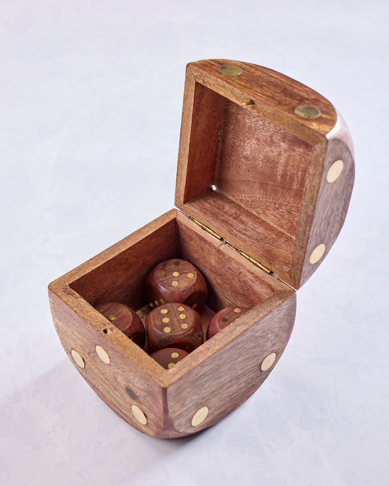 Open wooden dice box containing five brown dice, with additional pips decorating the box exterior.