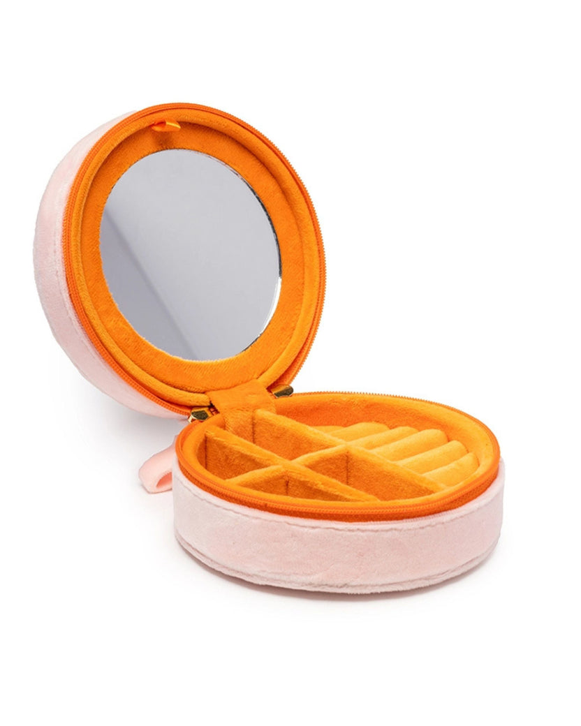 Open pink round jewelry case showing a mirror in the lid and divided compartments with ring slots.