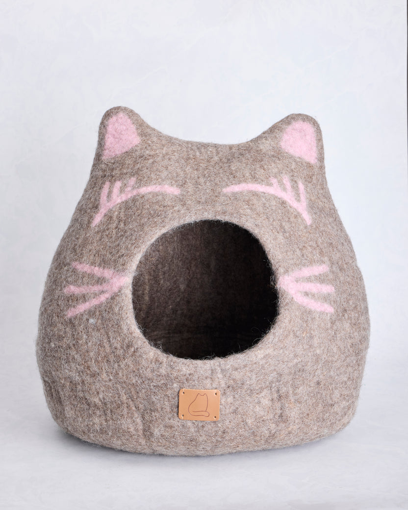 Front view of the taupe wool cat cave bed with pointed ears, pink facial details, and a round opening