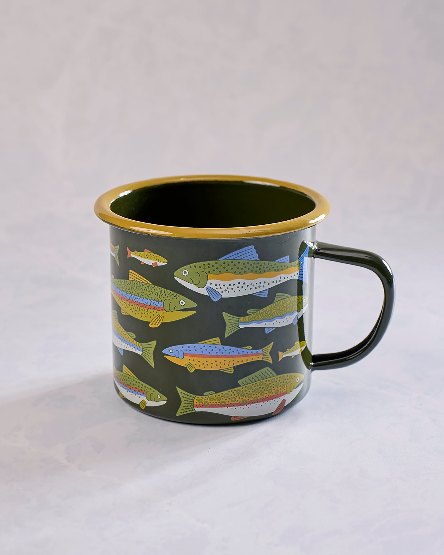 Green enamel mug with a black rim, black handle, and colorful trout illustrations