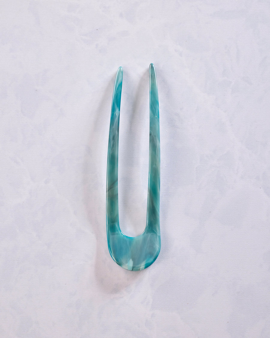 Turquoise marbled French hair pin shown in full, with two long prongs and a rounded base.