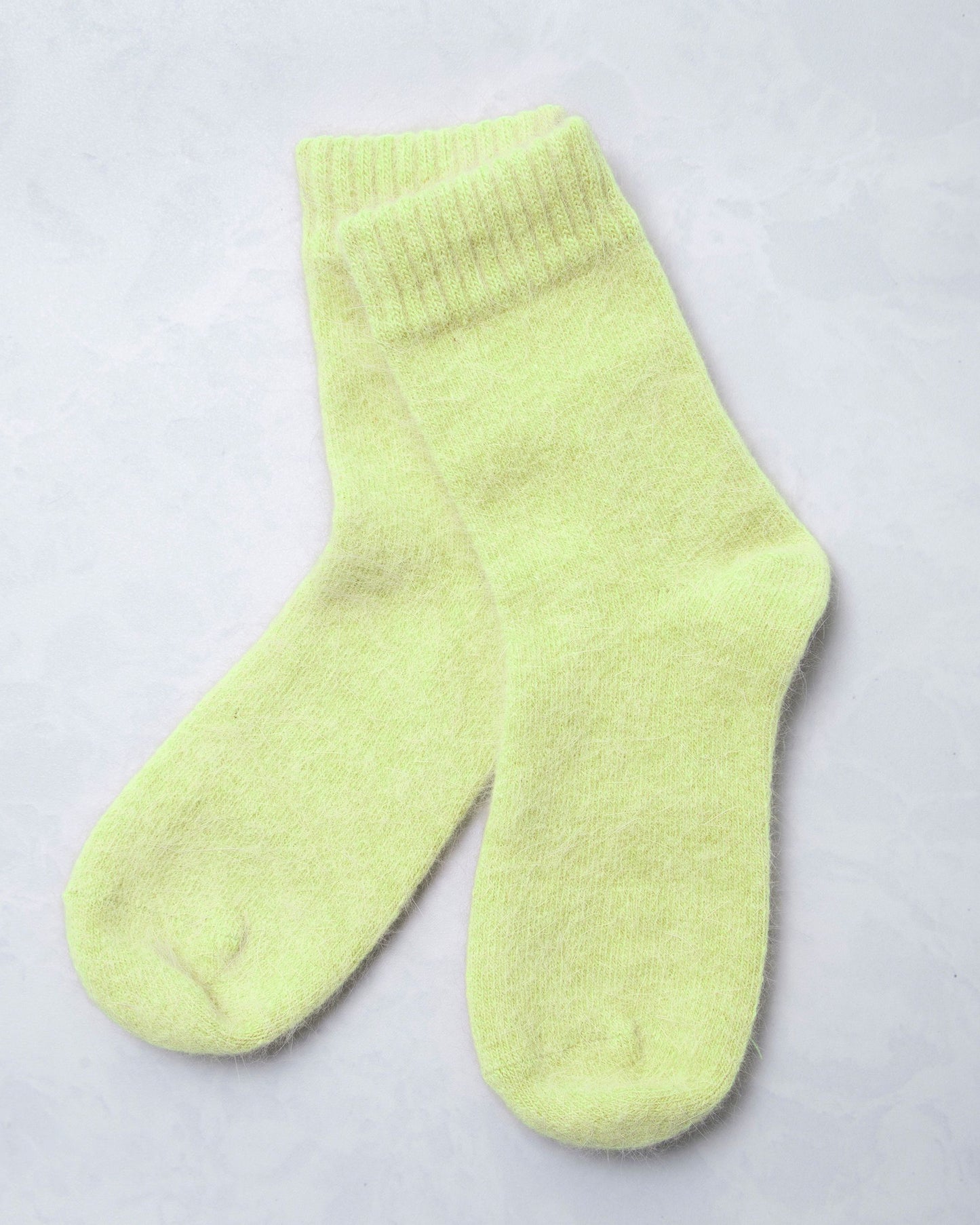 Pair of lime green cozy socks shown against a light background.