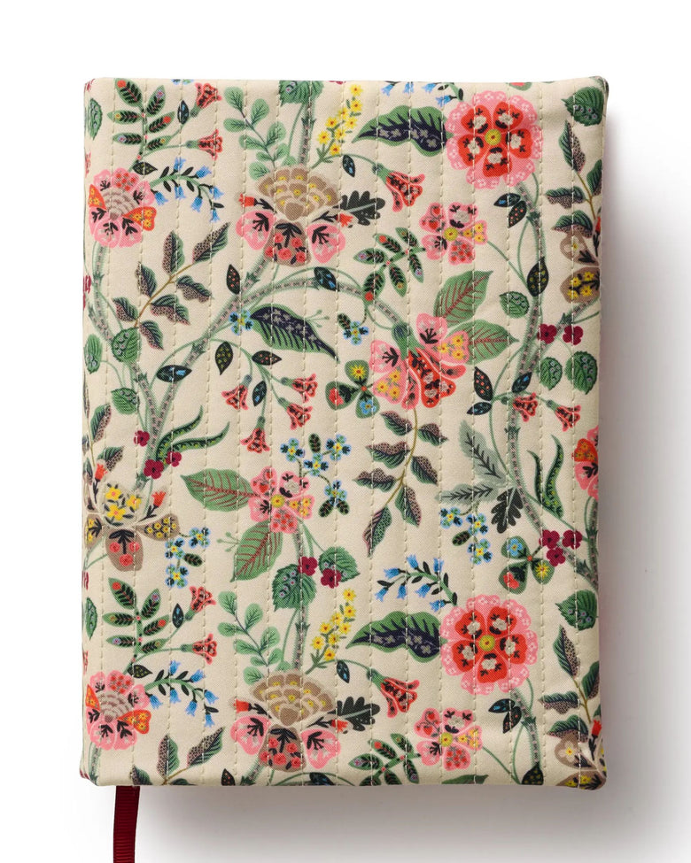 Closed Gracie journal with a cream quilted floral cover and a red ribbon bookmark.