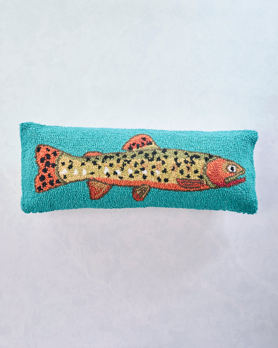 Front view of a lumbar pillow with a spotted trout on a turquoise background.