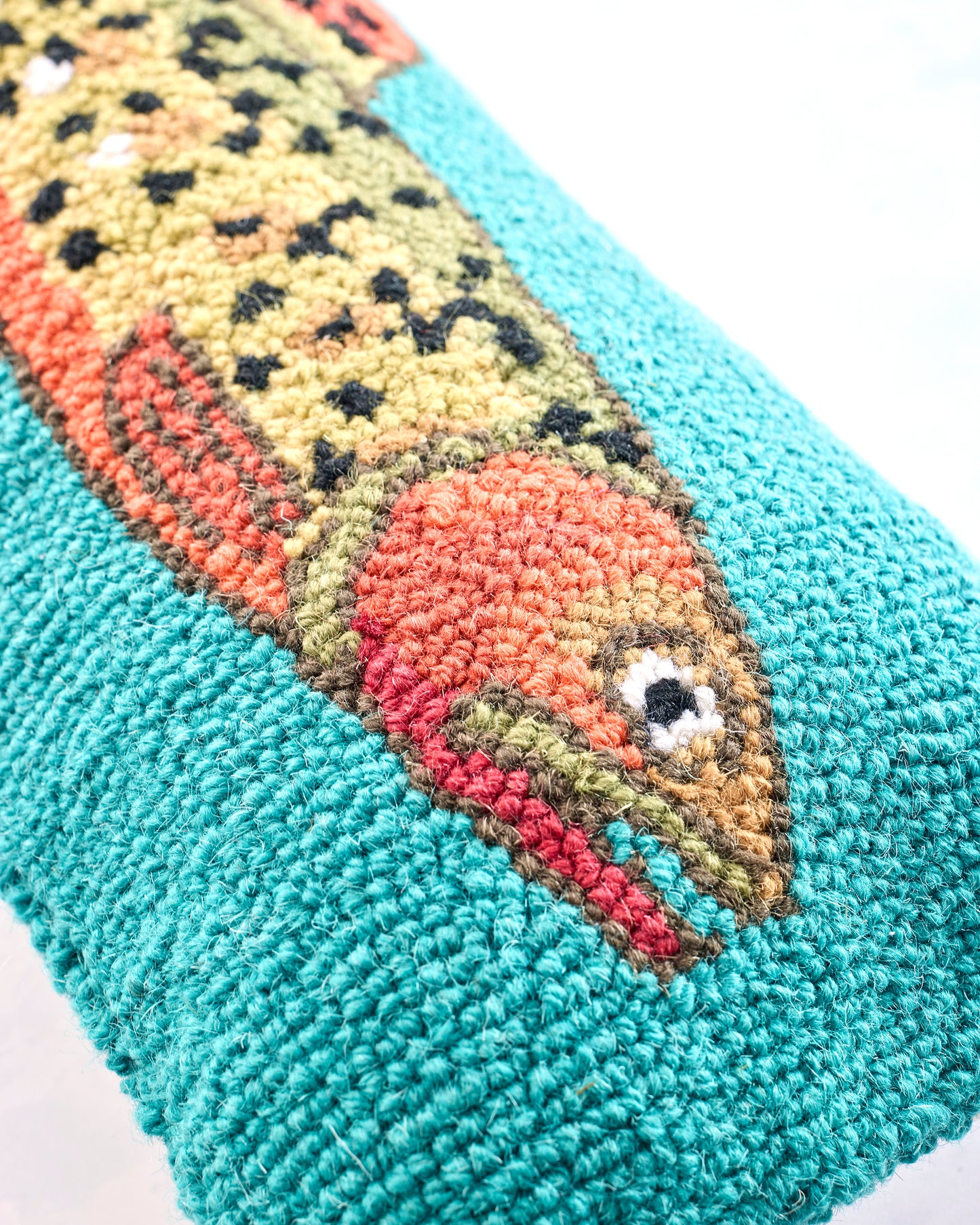 Close-up of the trout design showing its spotted body, fins, eye, and raised looped texture.