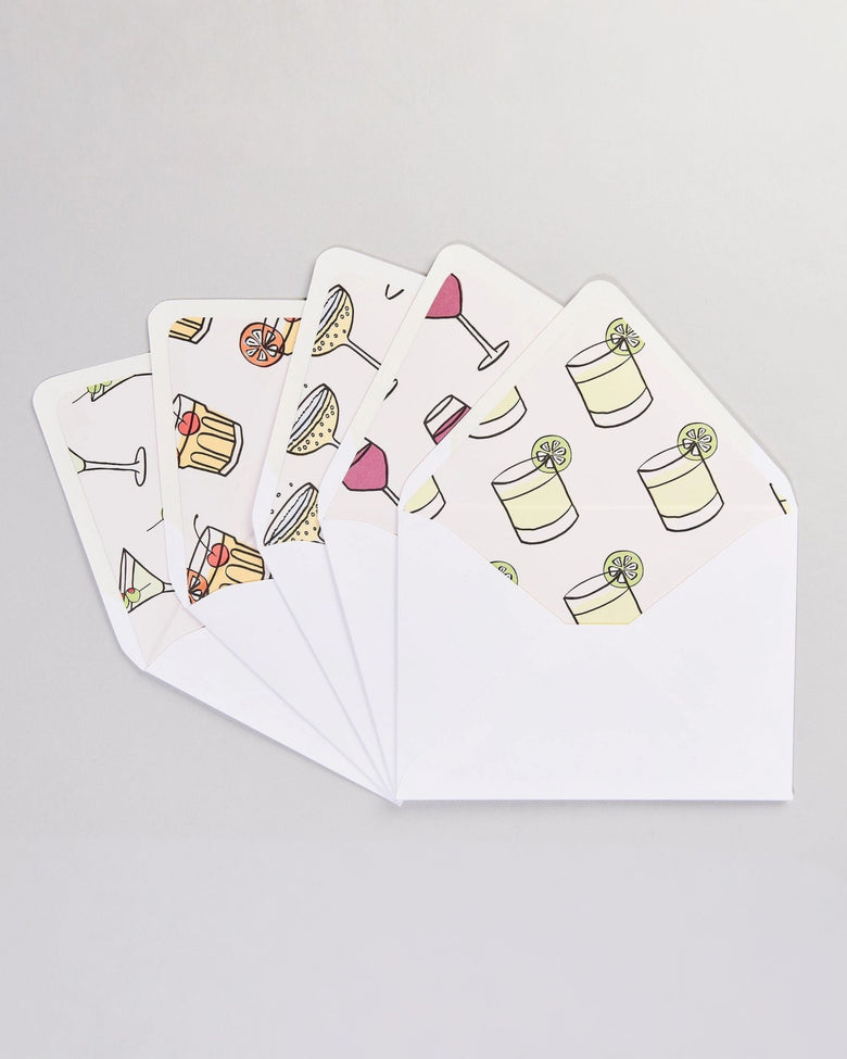 Set of white envelopes and cards with colorful cocktail and drink illustrations arranged in a fan.
