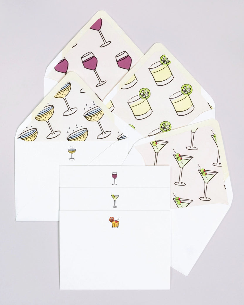 Happy Hour notecard set with white envelopes and cards featuring repeated illustrations of cocktails, wine glasses, and lime drinks.