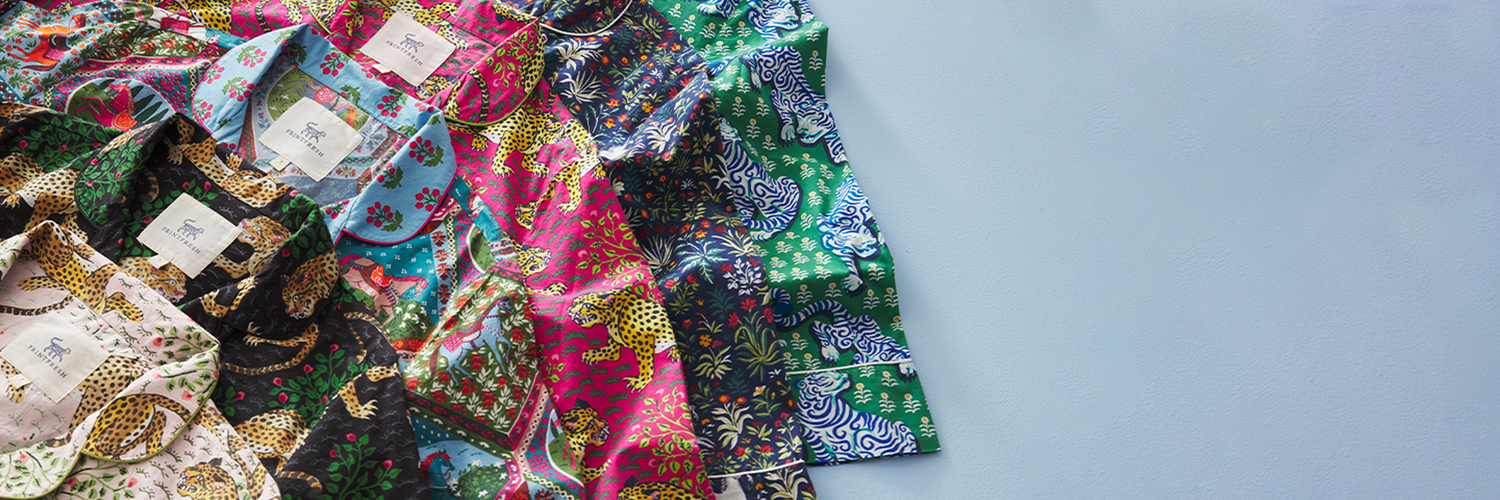 Colorful patterned pajama tops arranged together, accompanying Printfresh’s product-quality information.