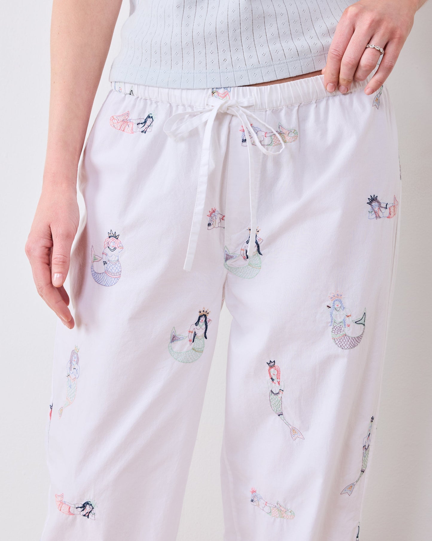 Close front view of the tall pajama pants showing the drawstring waist and mermaid motifs.